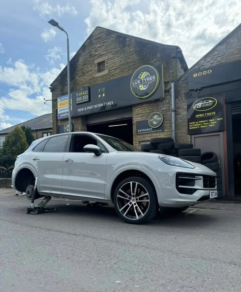 White Porsche Cayenne tyre change outside Lux Tyres